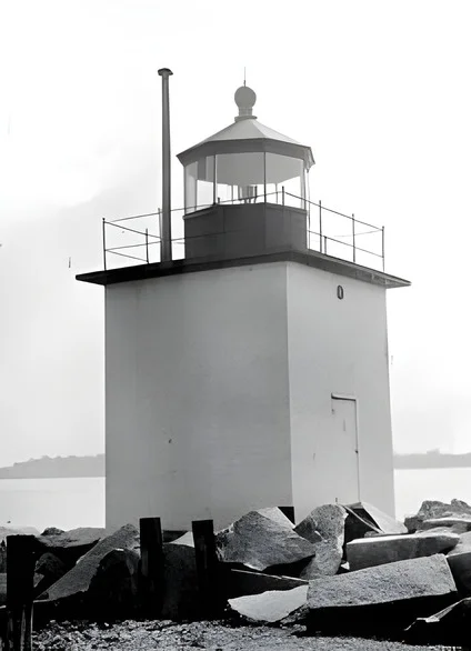 After AI enhancement (2x upscale): low-resolution photo of a small harbor lighthouse